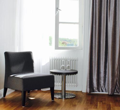 a chair and a table in a room with a window at Best Western Motala Stadshotell in Motala