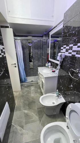 a bathroom with a toilet and a sink and a mirror at Cappuccini Sweet Home in Pozzuoli