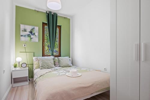 ein Schlafzimmer mit grünen Wänden und einem Bett mit Hut darauf in der Unterkunft Holiday house Mara with a private pool in Vodnjan