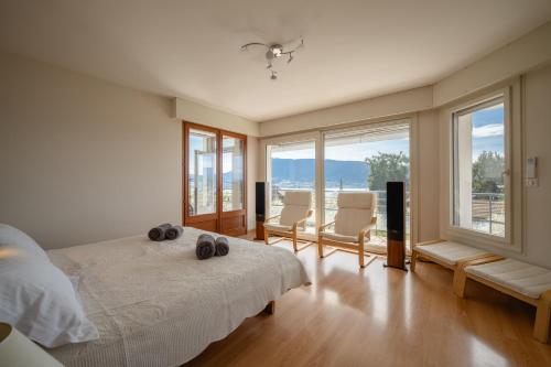 - une chambre avec un lit, 2 chaises et des fenêtres dans l'établissement Villa Elisa - vue lac, à Veyrier-du-Lac