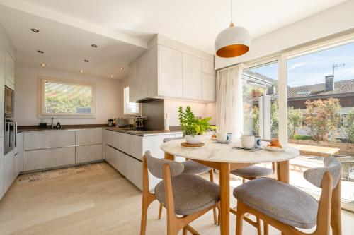 une cuisine et une salle à manger avec une table et des chaises dans l'établissement Villa Elisa - vue lac, à Veyrier-du-Lac
