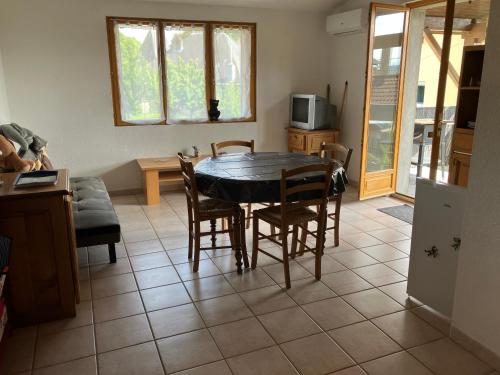 une cuisine et une salle à manger avec une table et des chaises dans l'établissement Appartement avec terrasse, à Abbenans