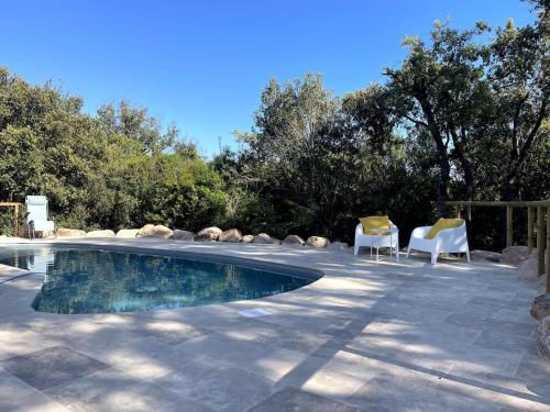 - une piscine dans une cour avec des chaises et des arbres dans l'établissement Villa Porto Vecchio, calme avec piscine, à Porto-Vecchio