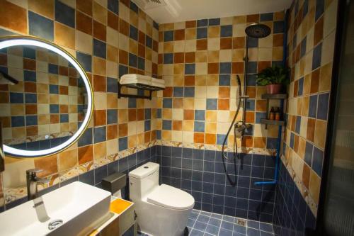 a bathroom with a toilet and a sink and a mirror at Ancient Road Yunju in Kashgar