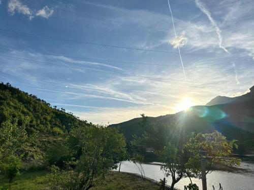 a view of the sun setting over a river at Breeze of the Drin Guesthouse Camping in Vau i Dejës