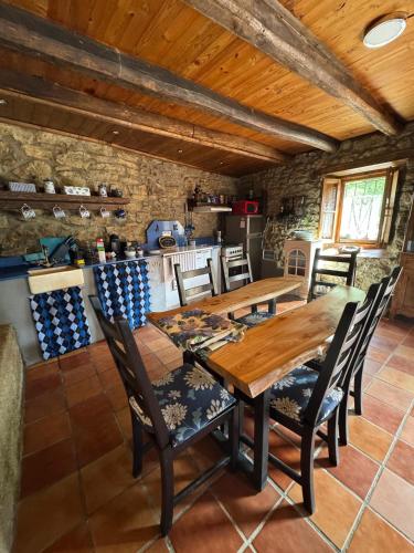 a dining room with a wooden table and chairs at Genciana, Casa Rural con encanto en La Montaña Leonesa in Cuevas de Viñayo