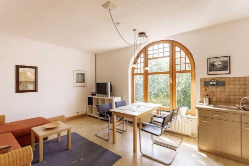 a living room with a table and a kitchen at Ferienwohnung Alter Dorfkrug 4 in Kronsgaard