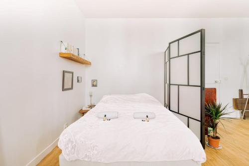 - une chambre dotée d'un lit blanc avec deux bougies dans l'établissement GuestReady - Stylish comfort near Montsouris, à Paris