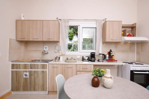 a kitchen with wooden cabinets and a table at Iris Apartments in Glyfada