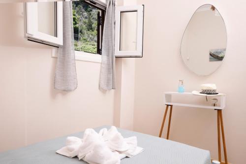 a white bathroom with a mirror and a sink at Iris Apartments in Glyfada