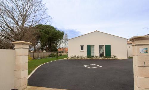 ein weißes Haus mit grünen Türen und einer Auffahrt in der Unterkunft La bourbonnaise in Corme-Royal