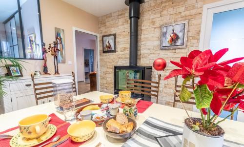 ein Esszimmer mit Tisch und Kamin in der Unterkunft La bourbonnaise in Corme-Royal