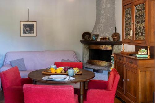a living room with a table and chairs with a fireplace at Dagli Olivari - Casa Ale in Gromo