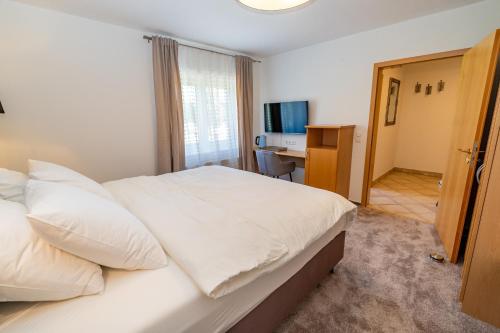 a hotel room with a bed and a desk at Hotel Grado in Ransbach-Baumbach