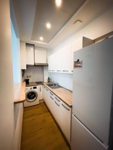 une cuisine avec des armoires blanches et un réfrigérateur blanc dans l'établissement Typical Nice neighborhood 15 min from beach, à Nice