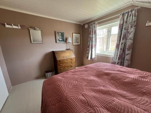a bedroom with a bed and a window and a dresser at Storåkeren - landlig idyll i Bindal 