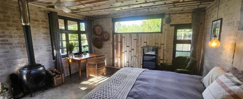 Le Petit Paradis في روبرتسون: غرفة نوم بسرير وموقد خشب