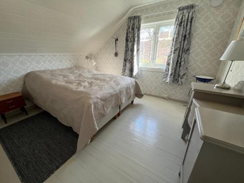 a small bedroom with a bed and a window at Storåkeren - landlig idyll i Bindal 
