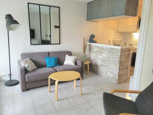 un salon avec un canapé et une table dans l'établissement Grand studio cabine 4 personnes Clim Très bien situé, au Cap d'Agde