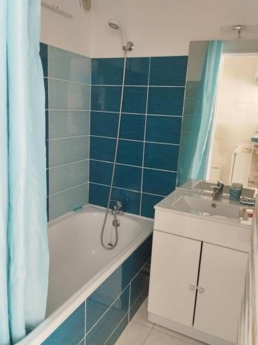 une salle de bain avec une baignoire et un lavabo dans l'établissement Grand studio cabine 4 personnes Clim Très bien situé, au Cap d'Agde
