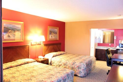 a hotel room with two beds and a desk at Valustay Inn Shakopee in Shakopee