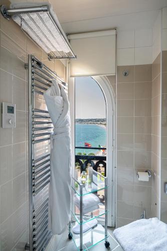 une robe accrochée à un porte-serviettes dans une salle de bain dans l'établissement Hotel Suisse, à Nice