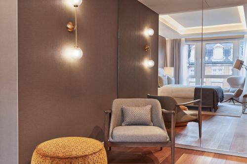 a room with a bed and a chair and a table at Steigenberger Hotel Hamburg in Hamburg