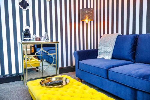 a living room with a blue couch and a table at 24 Catharine Street Hotel in Liverpool
