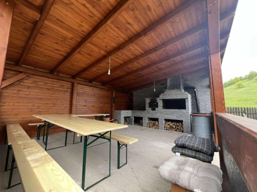 a large outdoor patio with a table and a fireplace at The Hygge House in Plopi
