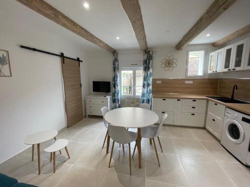 a kitchen with a table and chairs in a kitchen at Appartement cosy face au théâtre in Orange