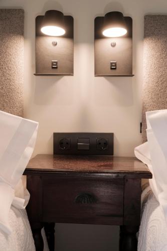 a bedroom with two beds and a wooden table with lights at Hosteria de Zubiri in Zubiri