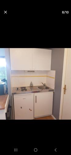 une petite cuisine avec un évier et une cuisinière dans l'établissement Appartement vannes cosy, à Vannes