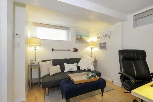 a living room with a black couch and a chair at Cozy Modern 2BR Near Grays Beach in Kingston