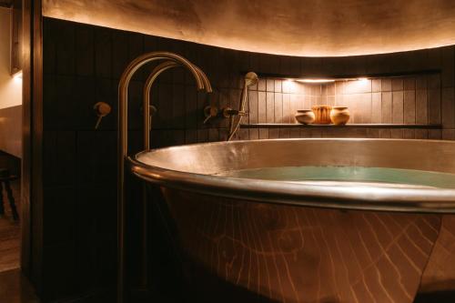a copper tub in a bathroom with a sink at No.124 by GuestHouse, Brighton in Brighton & Hove