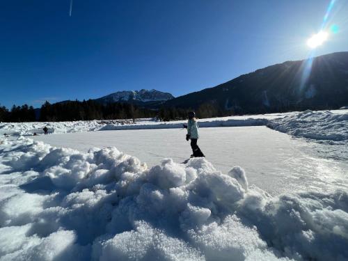 a person standing on a frozen lake in the snow at Binter Haus -Rattendorf in Rattendorf