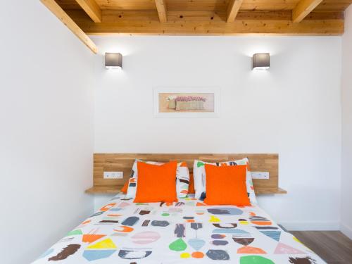 sypialnia z łóżkiem z pomarańczowymi poduszkami w obiekcie Apartamento Minimalista con Terraza, WiFi y a 1 Minuto de la Playa - ES-279-4 w mieście Garachico