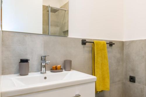 a bathroom with a sink and a yellow towel at B&B apartment 2 in Rijeka