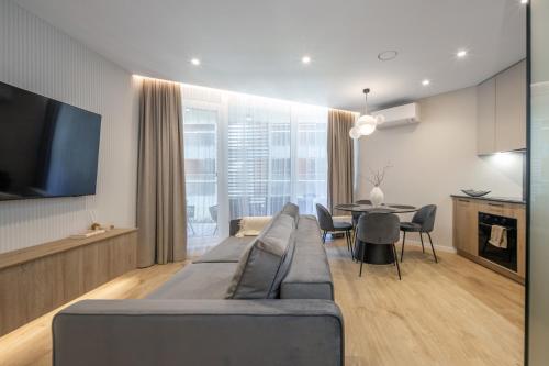 a living room with a large couch and a table at Sea Whisper apartamentai Daukanto g Palanga in Palanga