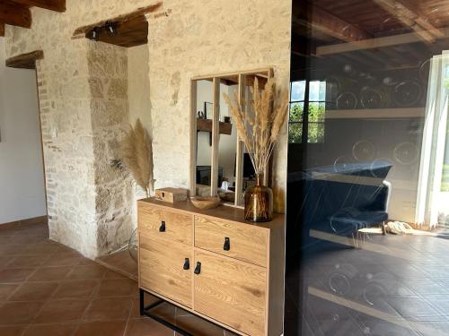a wooden dresser in a room with a mirror at Gite les grandes vignes in Saint-Sernin