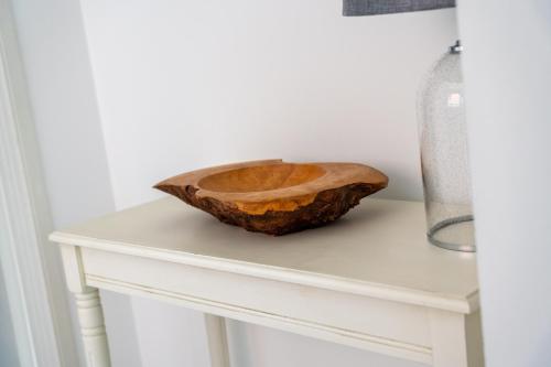 a wooden bowl sitting on top of a white table at Belmont Apartment in Belfast