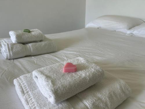 a bed with towels and a pink heart on it at Gite les grandes vignes in Saint-Sernin