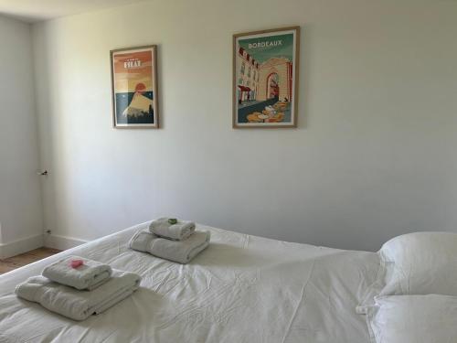 a white bed with two towels on top of it at Gite les grandes vignes in Saint-Sernin
