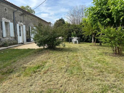 a yard with a table in the back of a building at Gite les grandes vignes in Saint-Sernin