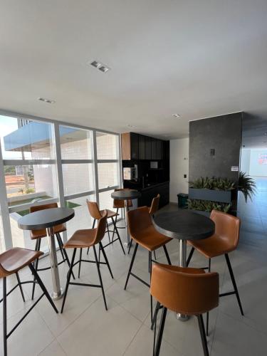a room with tables and chairs and a kitchen at Westfit Barreto 03 in Mossoró