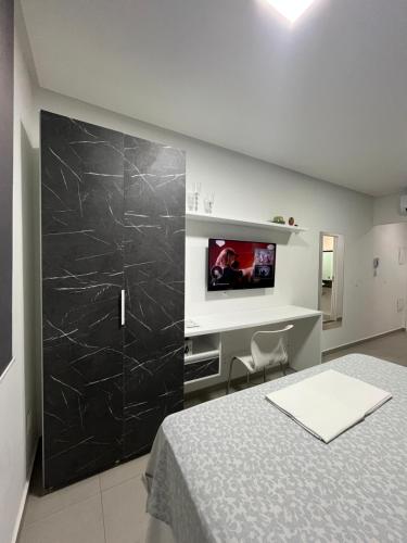 a bedroom with a bed and a tv on a wall at Westfit Barreto 03 in Mossoró