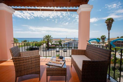 a patio with a table and chairs and the ocean at Iris Apartments in Glyfada