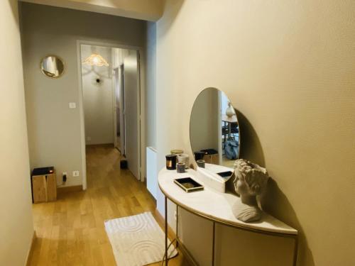 une salle de bain avec un lavabo et un miroir au mur dans l'établissement LE St LAURENT, à Rodez