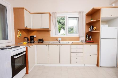 a kitchen with white cabinets and a sink at Iris Apartments in Glyfada
