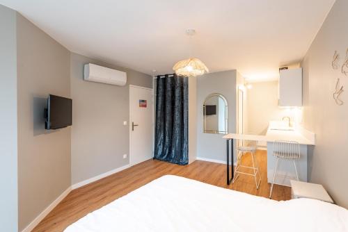 - une chambre avec un lit, un lavabo et un bureau dans l'établissement M40 Joli studio au calme, à Annemasse