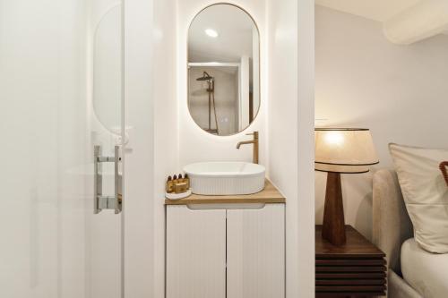 une salle de bain avec un lavabo et un miroir dans l'établissement Saint Tropez 104 rue Allard 3e G, à Saint-Tropez